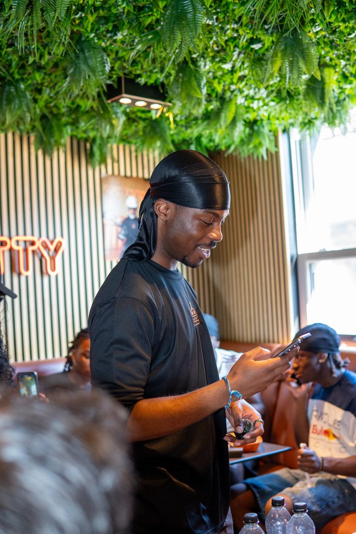 Keran on his phone at a brand event